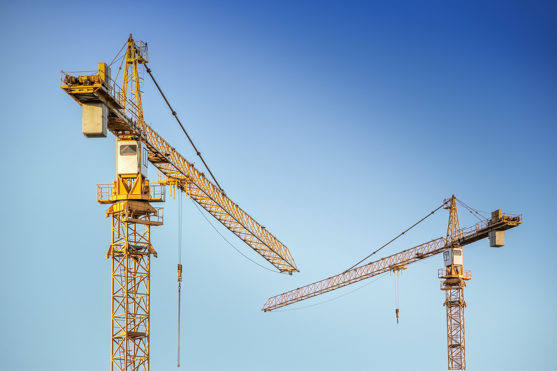 Construction cranes against a blue sky