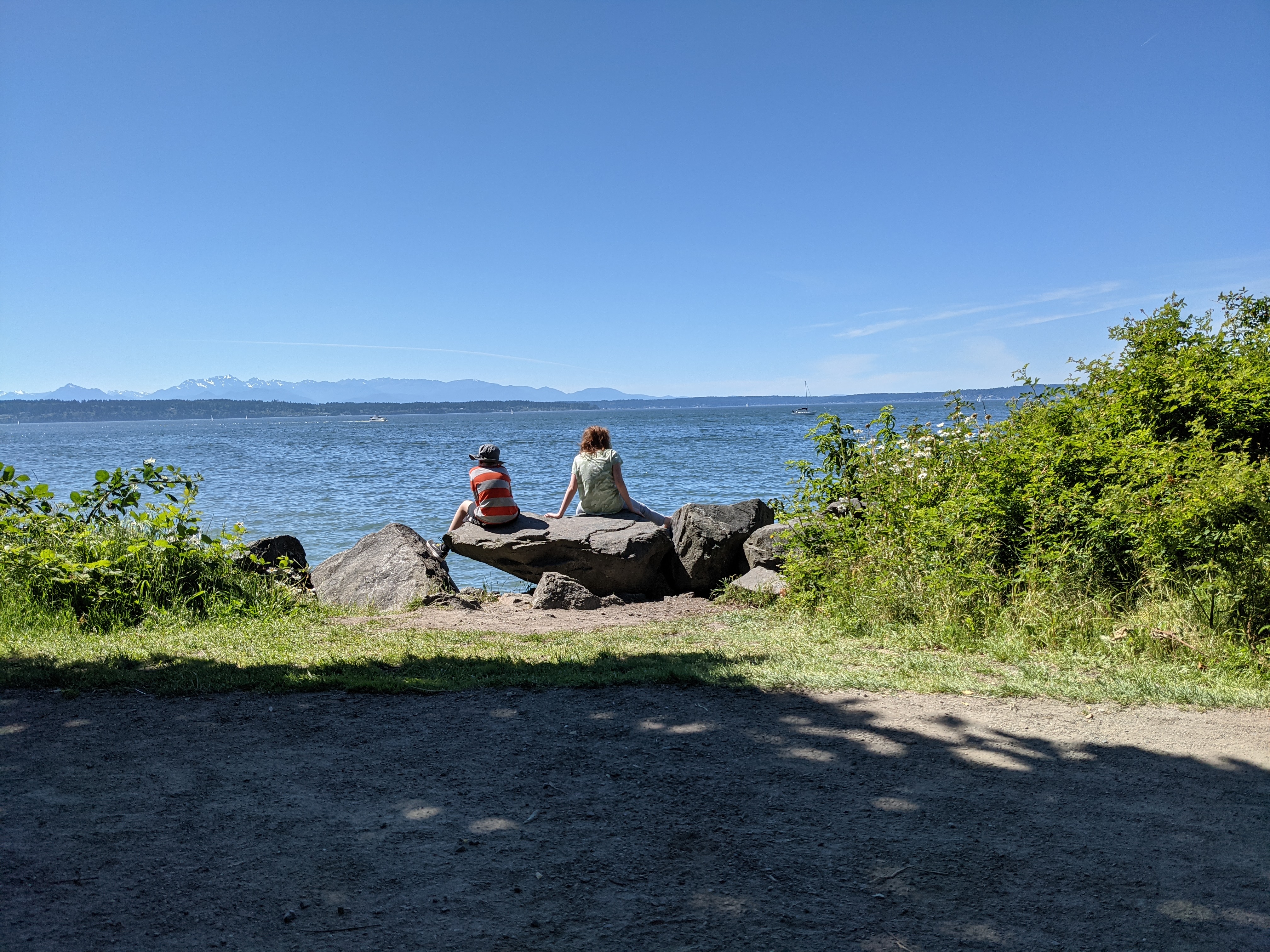 2 kids on rock looking out at water
