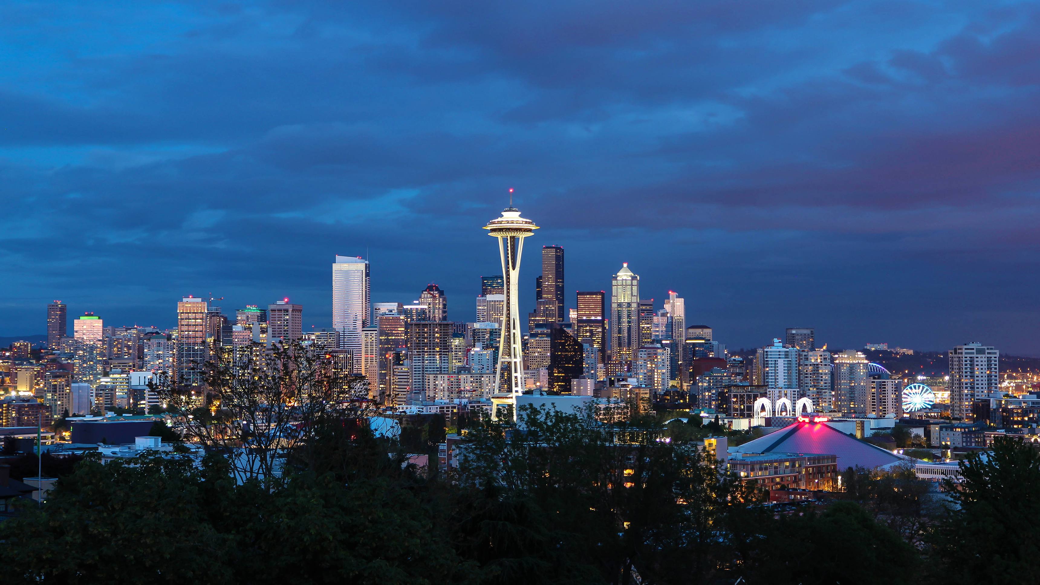 Seattle skyline at dusk, featuring the Space Needle and city lights.