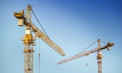 Construction cranes against a blue sky