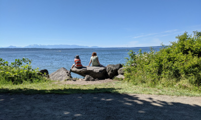 2 kids on rock looking out at water