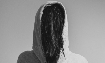 Person in hoodie with hair obscuring face