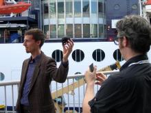 Dominic Muren holds a copy of his skull while Bre Pettis takes a picture